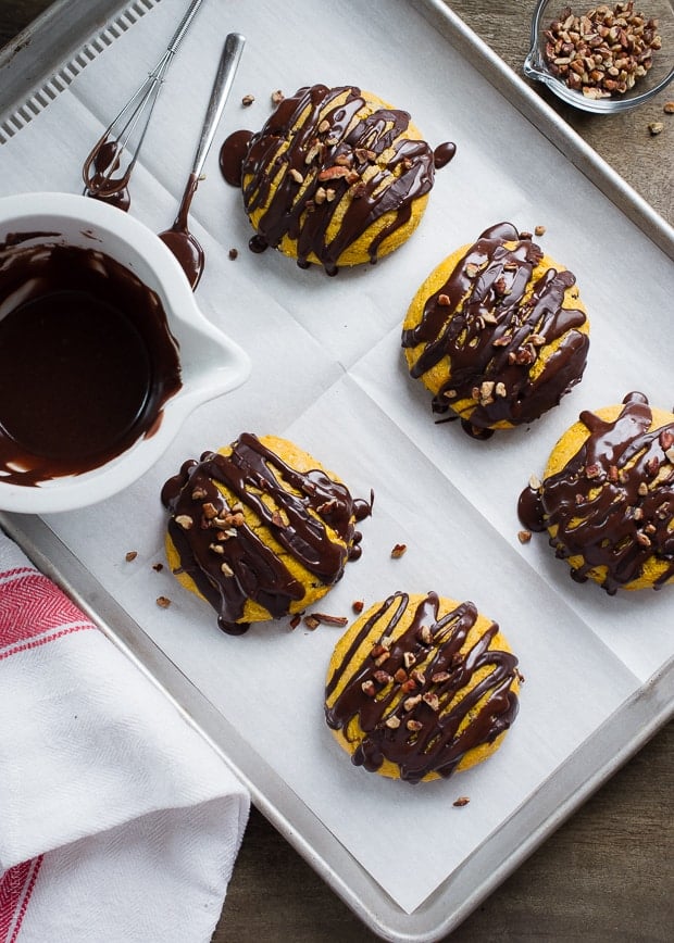 Pumpkin Cornmeal Scones drizzled with chocolate and topped with pecans.