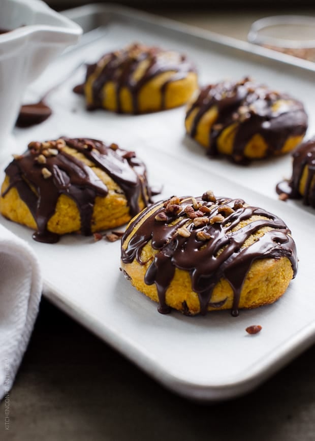 Pumpkin Cornmeal Scones drizzled with chocolate and topped with pecans.