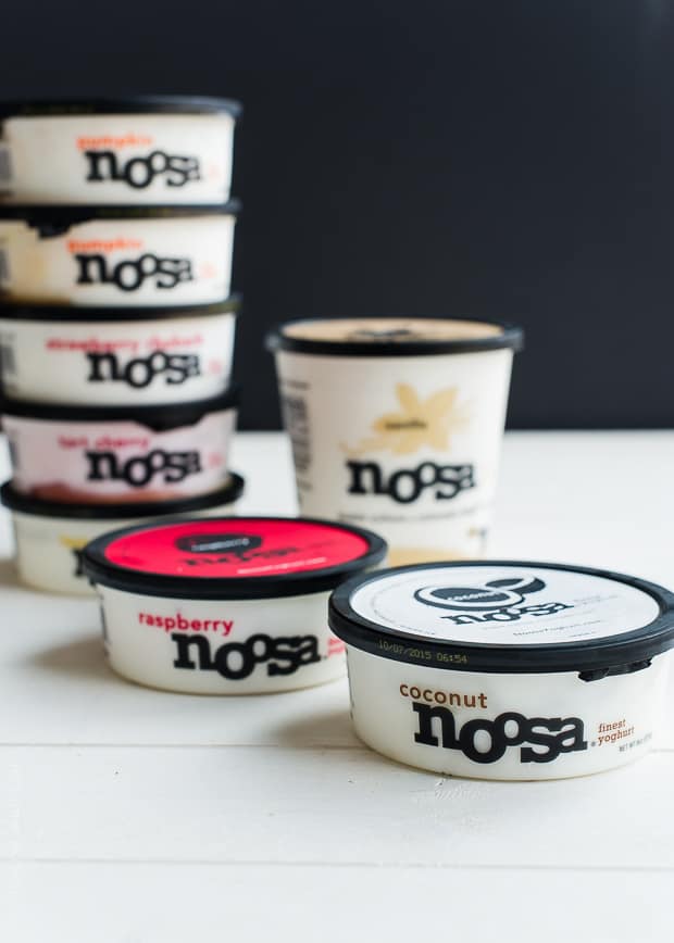 containers of noosa yogurt against a black background