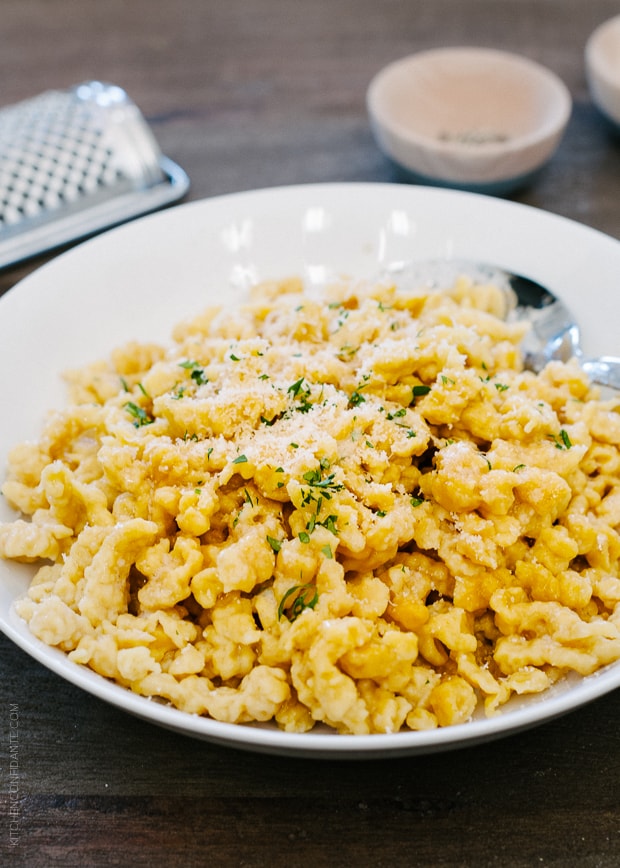 Brown Butter Pumpkin Spaetzle in a white dish garnished with finely chopped parsley. 