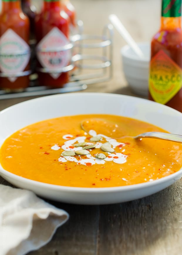 White bowl filled with Habanero Spiced Pumpkin Soup and topped with pumpkin seeds.