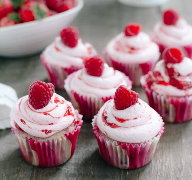 Roasted Berry Cupcakes topped with pink buttercream and a single raspberry.