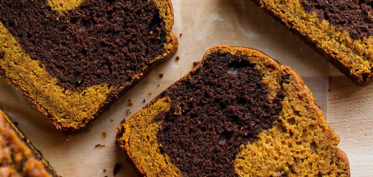 Slices of Chocolate Marble Pumpkin Bread on a cutting board.