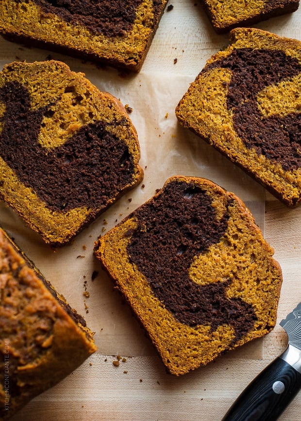 Slices of Chocolate Marble Pumpkin Bread arranged on a wooden counter top.