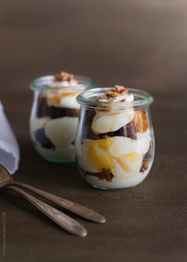 Pumpkin Bread Parfaits in glass jars with spoons alongside.