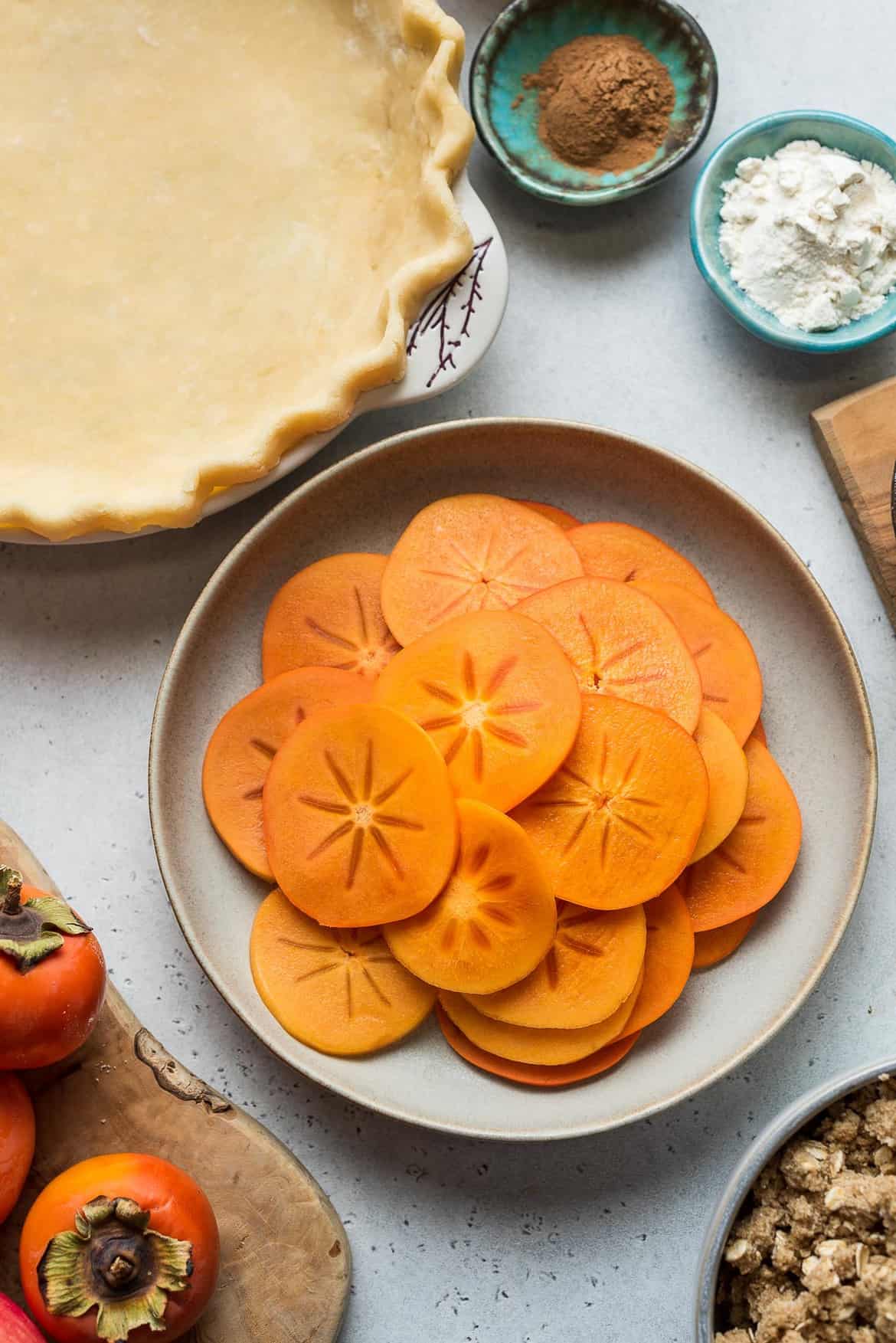 Slices of fresh persimmons on a wooden surface.