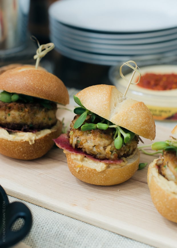 Pretzel Crusted Crab Cake Sliders in a row on a serving board.