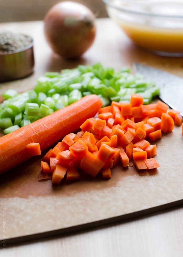 Diced carrots and celery on a wooden surface.