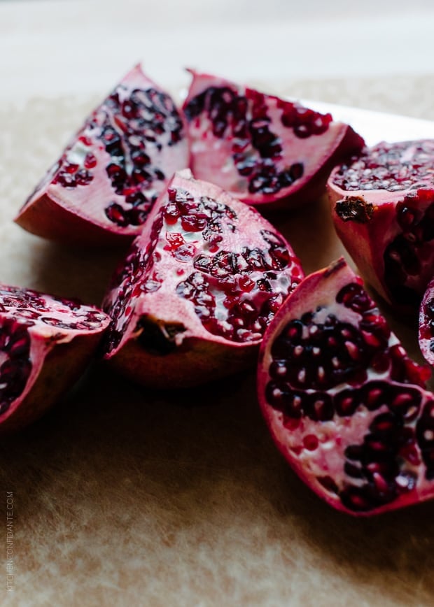 Quartered pomegranates on a counter top.