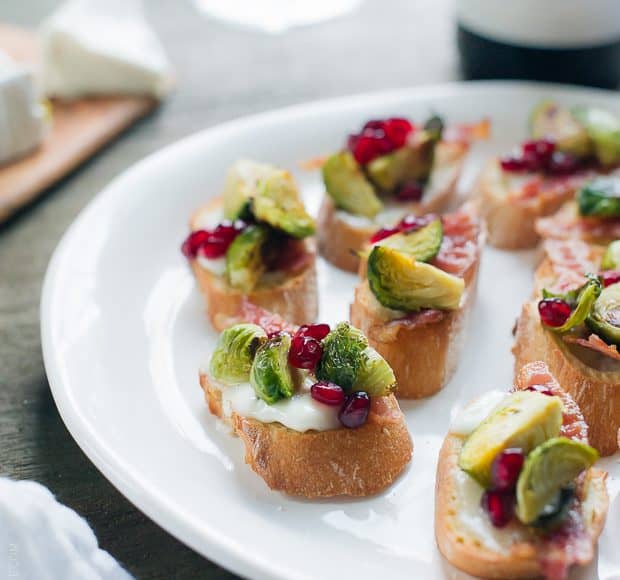 Roasted Brussels Sprouts with Bacon Crostini arranged on a white serving platter.