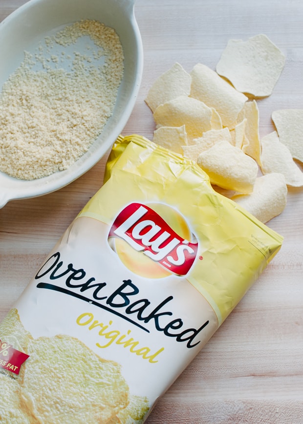 An open bag of baked potato chips with some chips spilling onto the counter top.