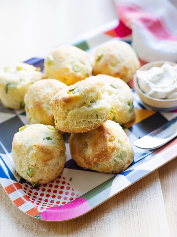 Cream Cheese and Green Onion Biscuits stacked on a serving platter.