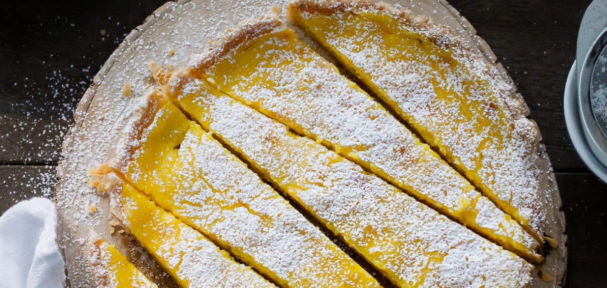 A Meyer Lemon Tart sliced on a serving platter.