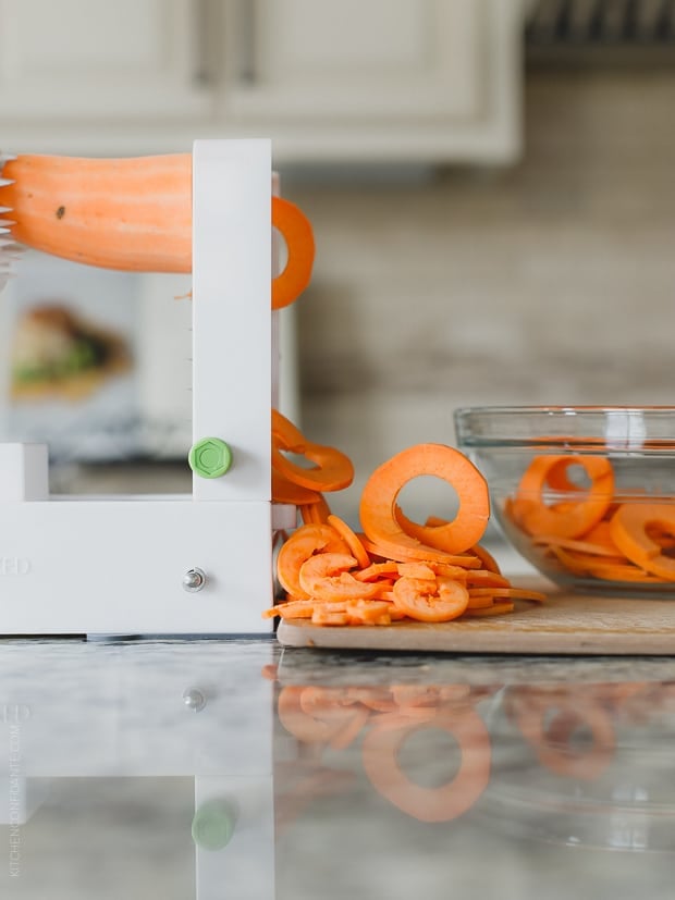 Using a spiralizer to make ribbons of sweet potato.