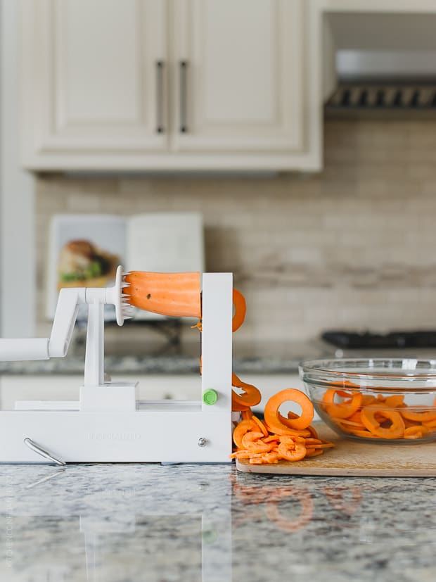 Spiralizing sweet potatoes in a kitchen.