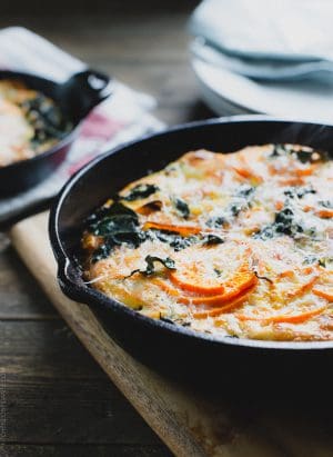 A cast iron skillet filled with a freshly baked Spiralized Sweet Potato Kale Egg White Frittata.