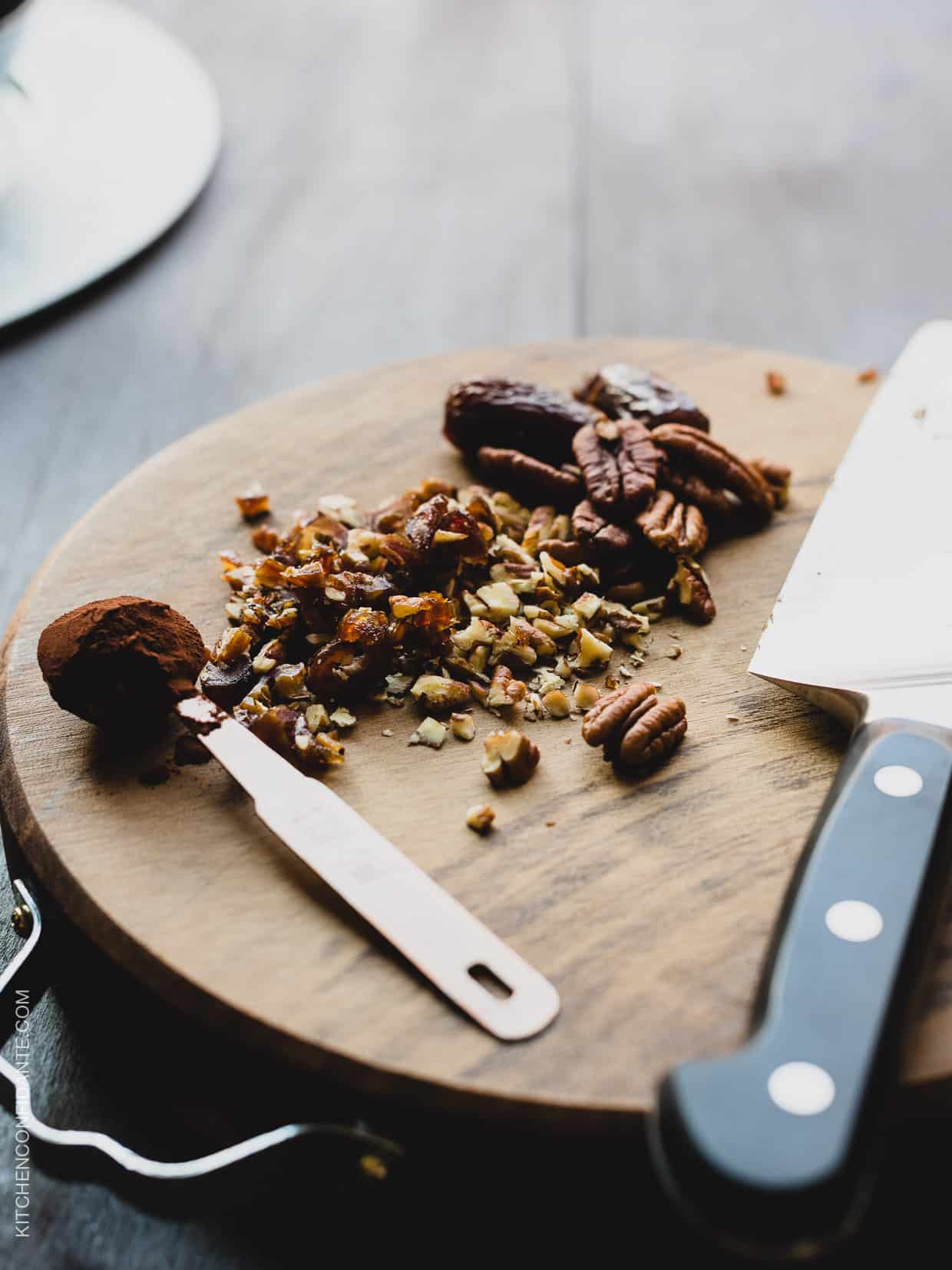 Chopped dates and pecans on a wooden cutting board.