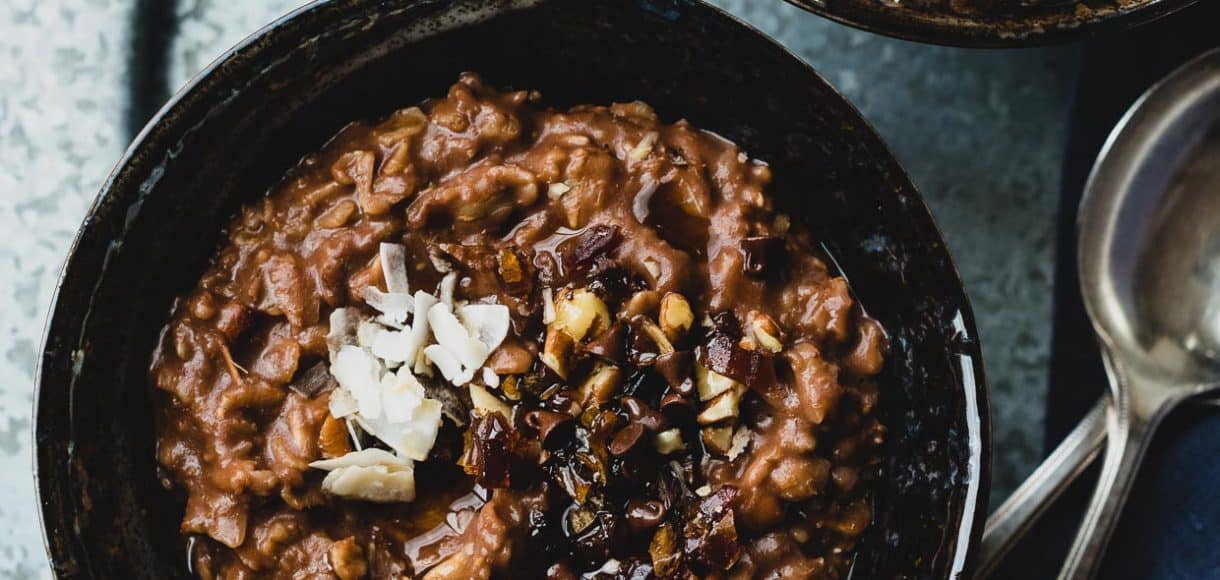 Two bowls of Chocolate Coconut Oat Porridge garnished with coconut and mini chocolate chips.