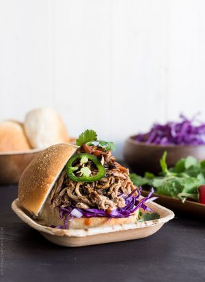 Filipino Adobo-style Pulled Pork Sandwich layered with red cabbage, a few leaves of cilantro and sriracha.