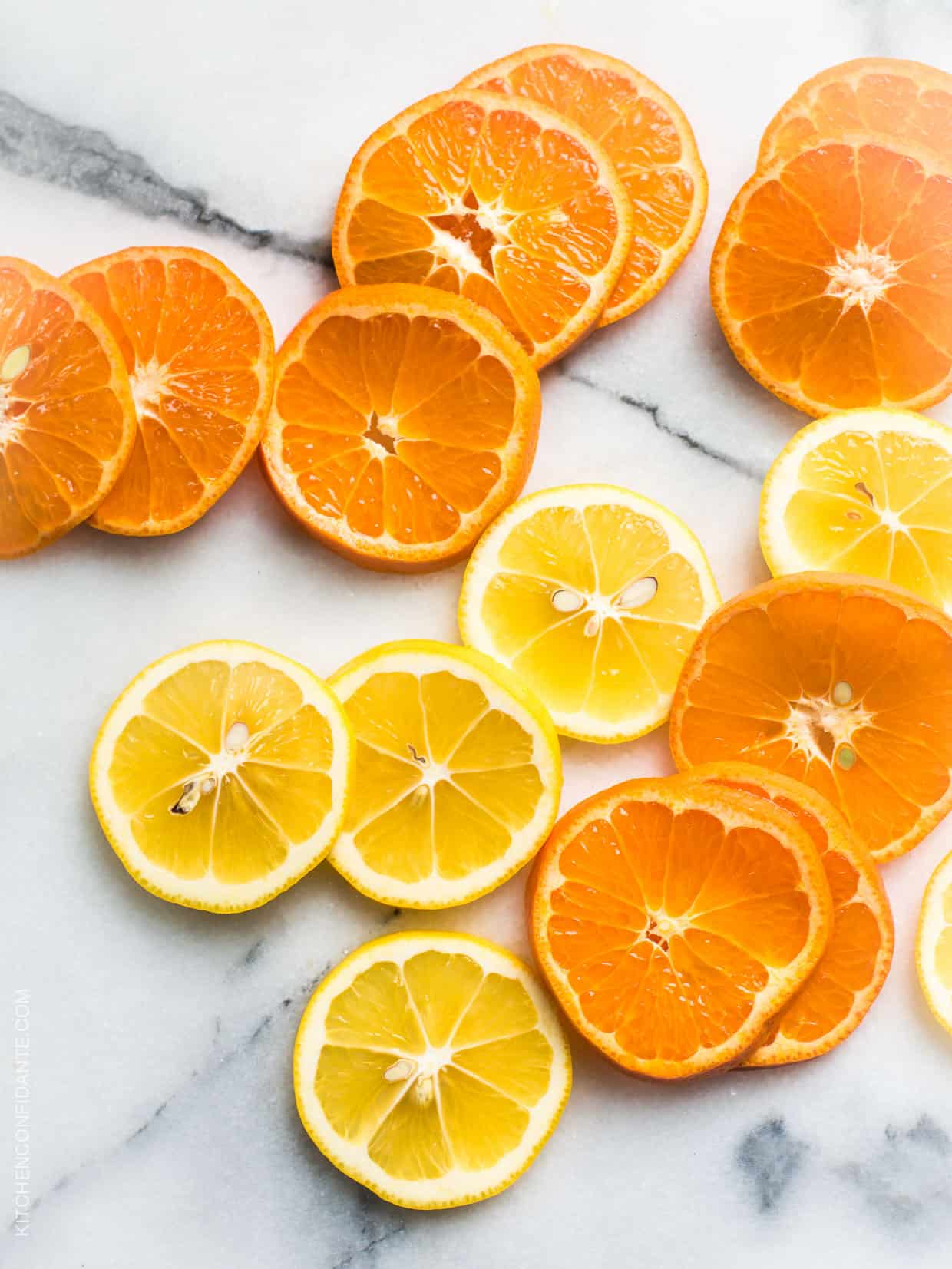 Slices of citrus fruit on a marble surface.