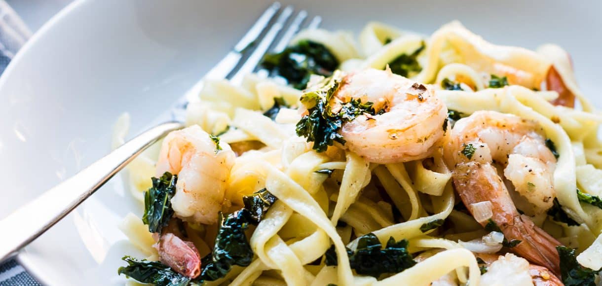 Freshly cooked linguine, leafy kale, and shrimp twirl together on a dinner plate to create Kale and Shrimp Scampi.