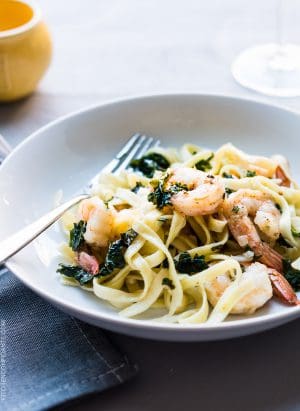Freshly cooked linguine, leafy kale, and shrimp twirl together on a dinner plate to create Kale and Shrimp Scampi.