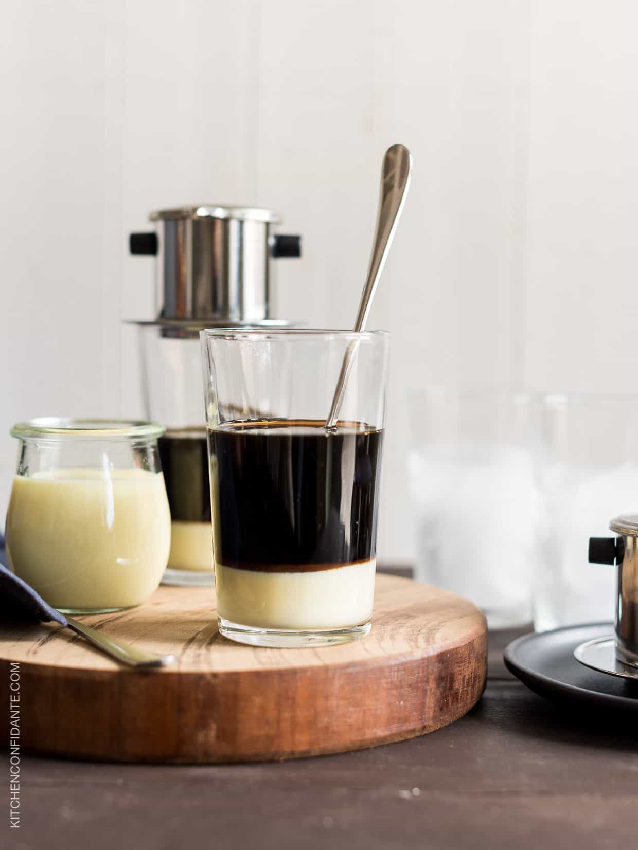 A glass with a few inches of condensed milk topped with freshly made coffee from a phin filter.