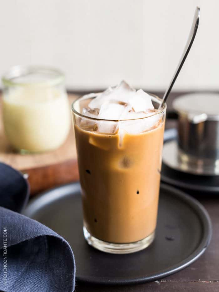 A tall glass of Vietnamese Iced Coffee (Ca Phe Sua Da) with a spoon to stir.