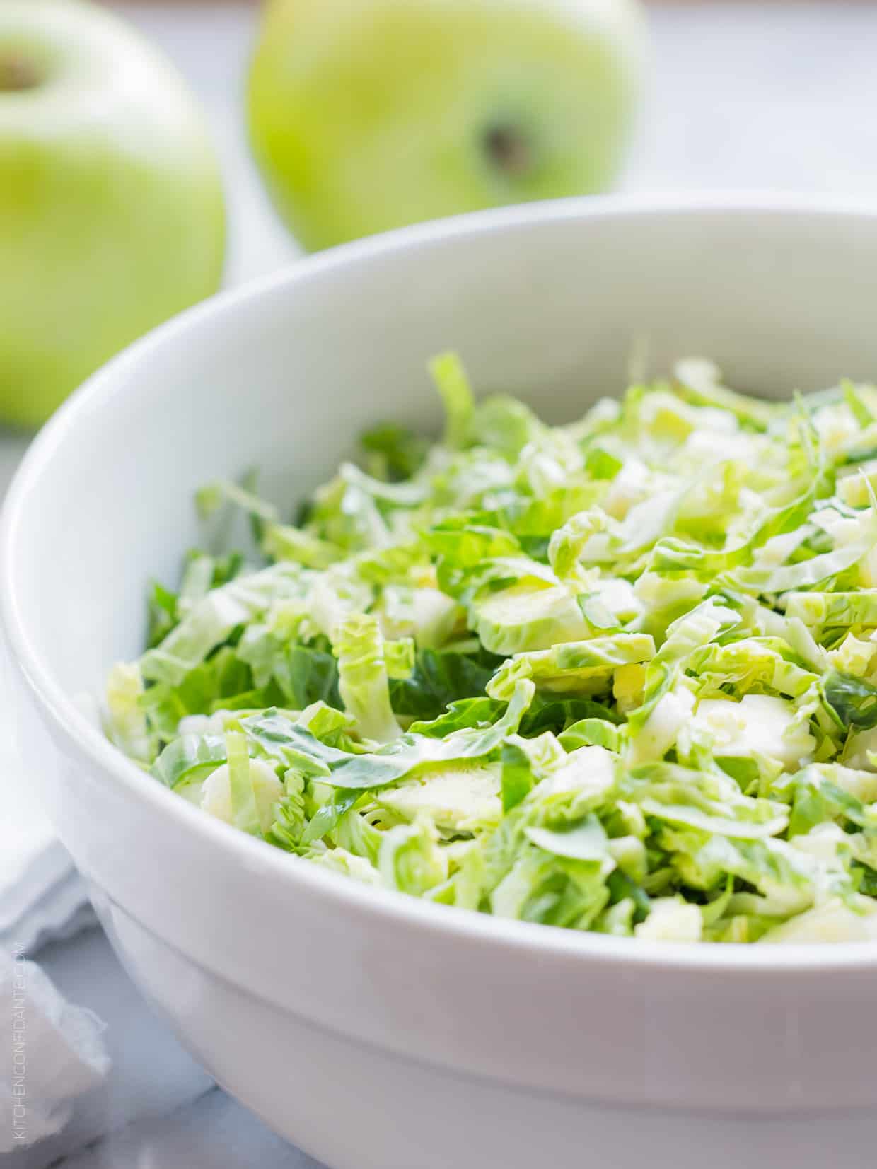 Shredded Brussels sprouts in a white bowl.