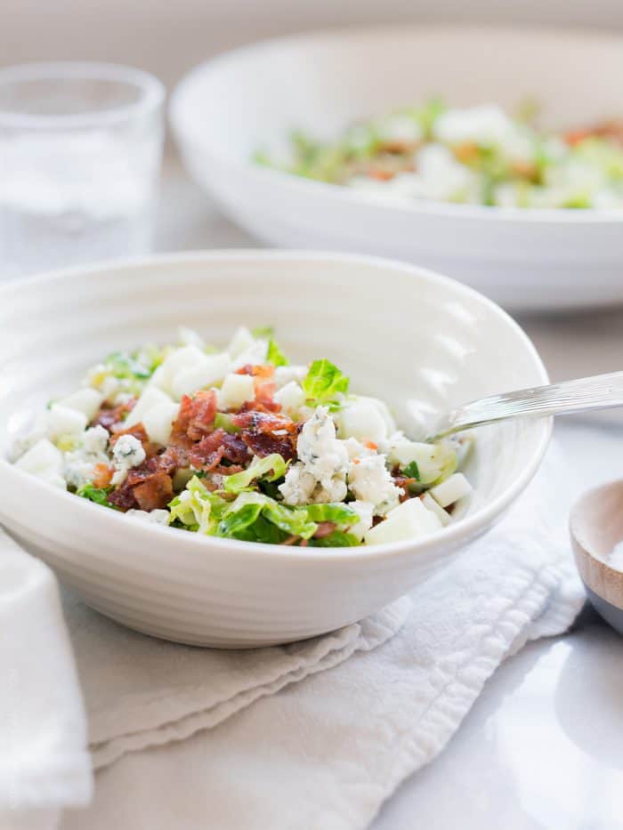 A white bowl filled with Shredded Brussels Sprouts Salad.