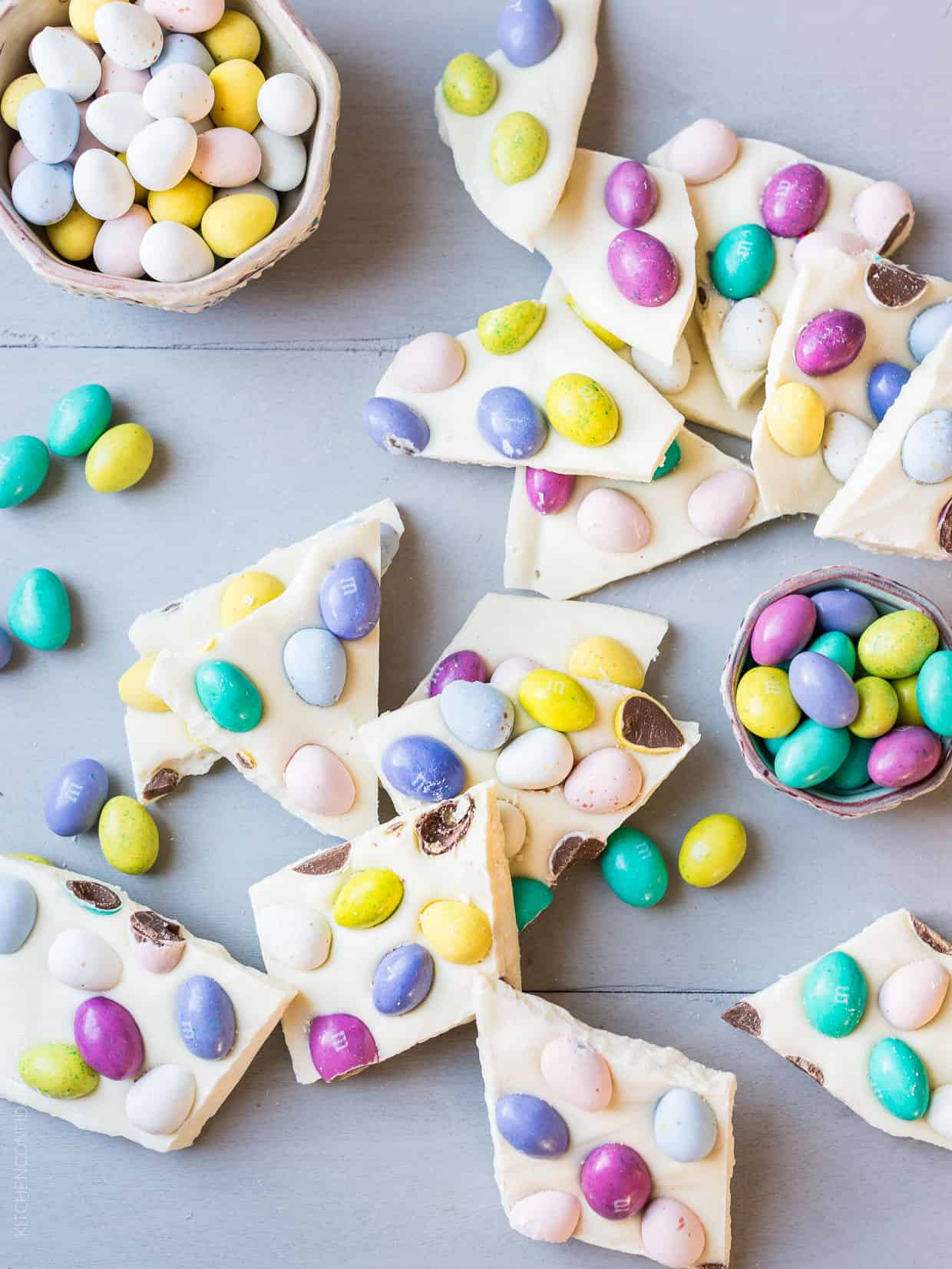 Colorful Easter Bark surrounded by bowls of bright candy eggs.