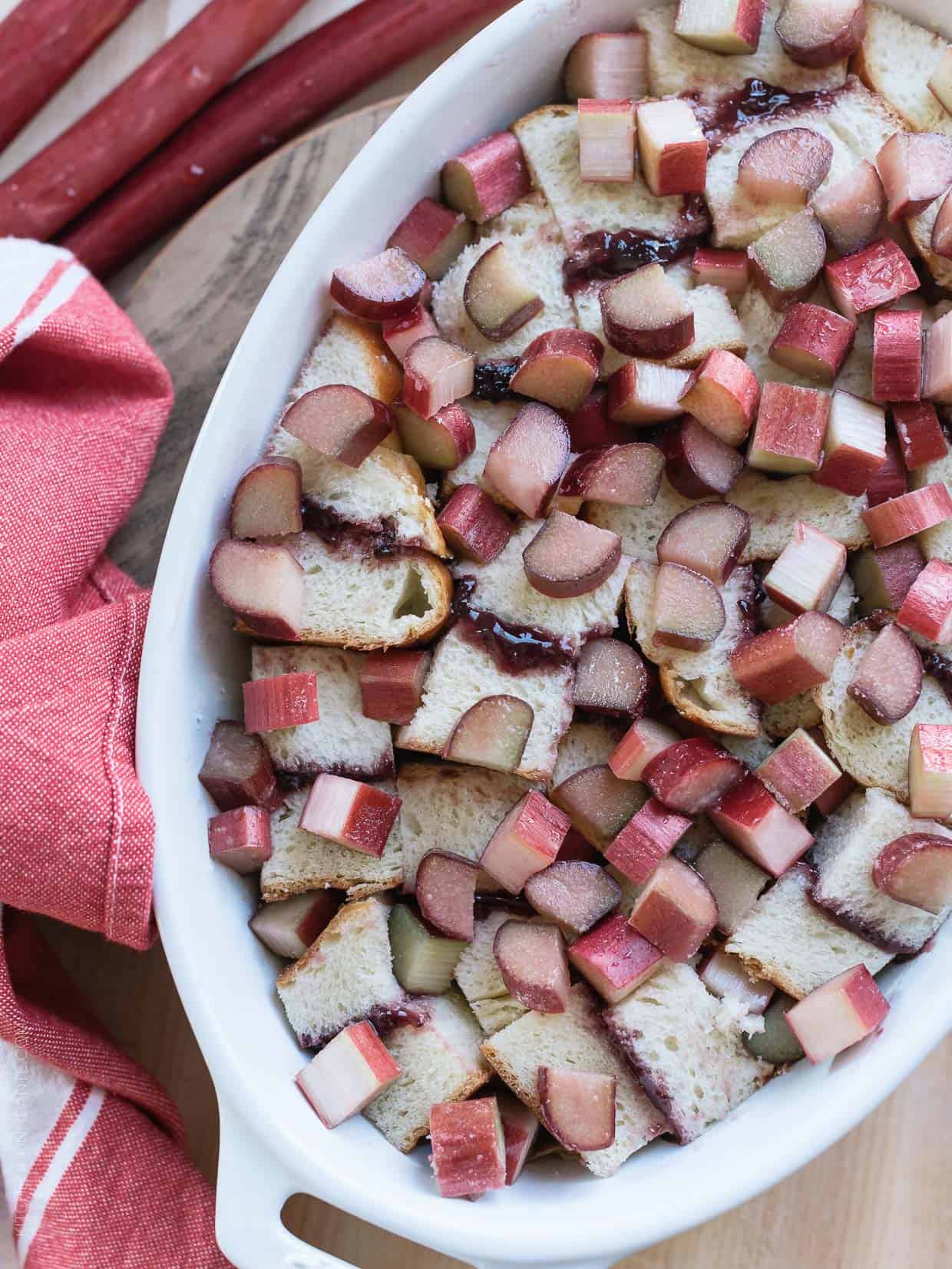 Chopped rhubarb layered with leftover brioche and strawberry jam for Rhubarb Bread Pudding.