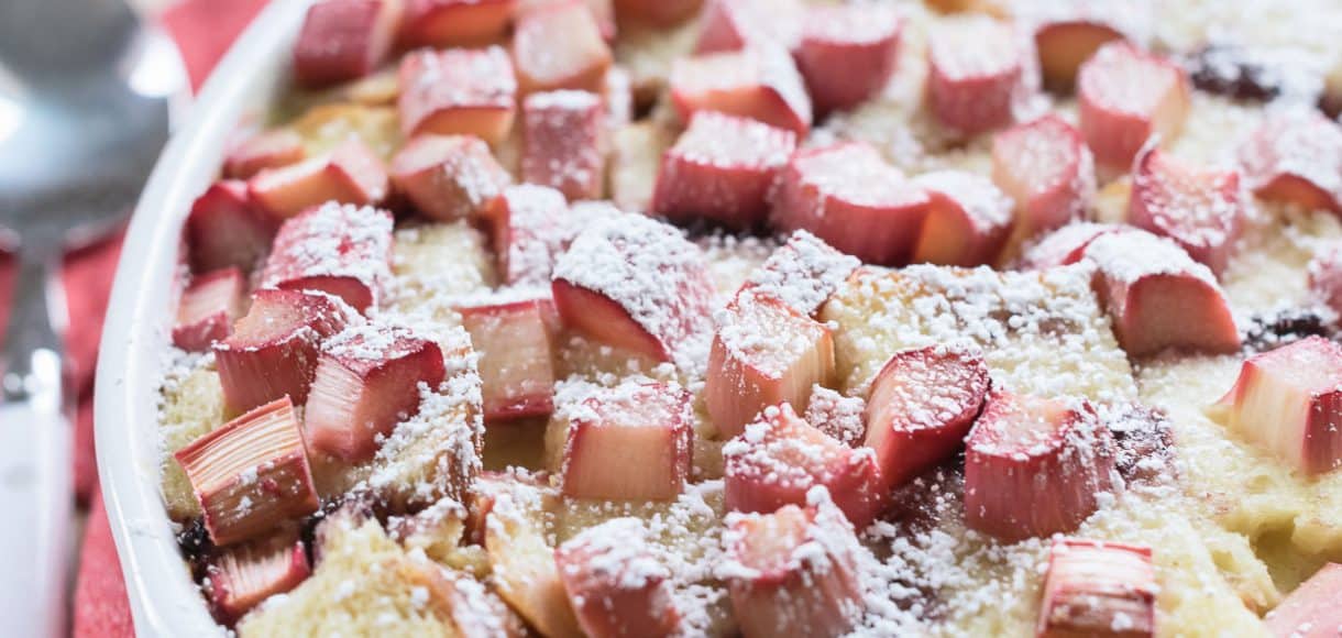 Rhubarb Breading Pudding in a white baking dish on a red and white cloth napkin.