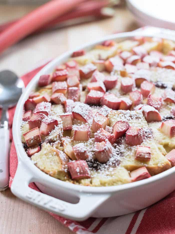 Rhubarb Breading Pudding in a white baking dish on a red and white cloth napkin.
