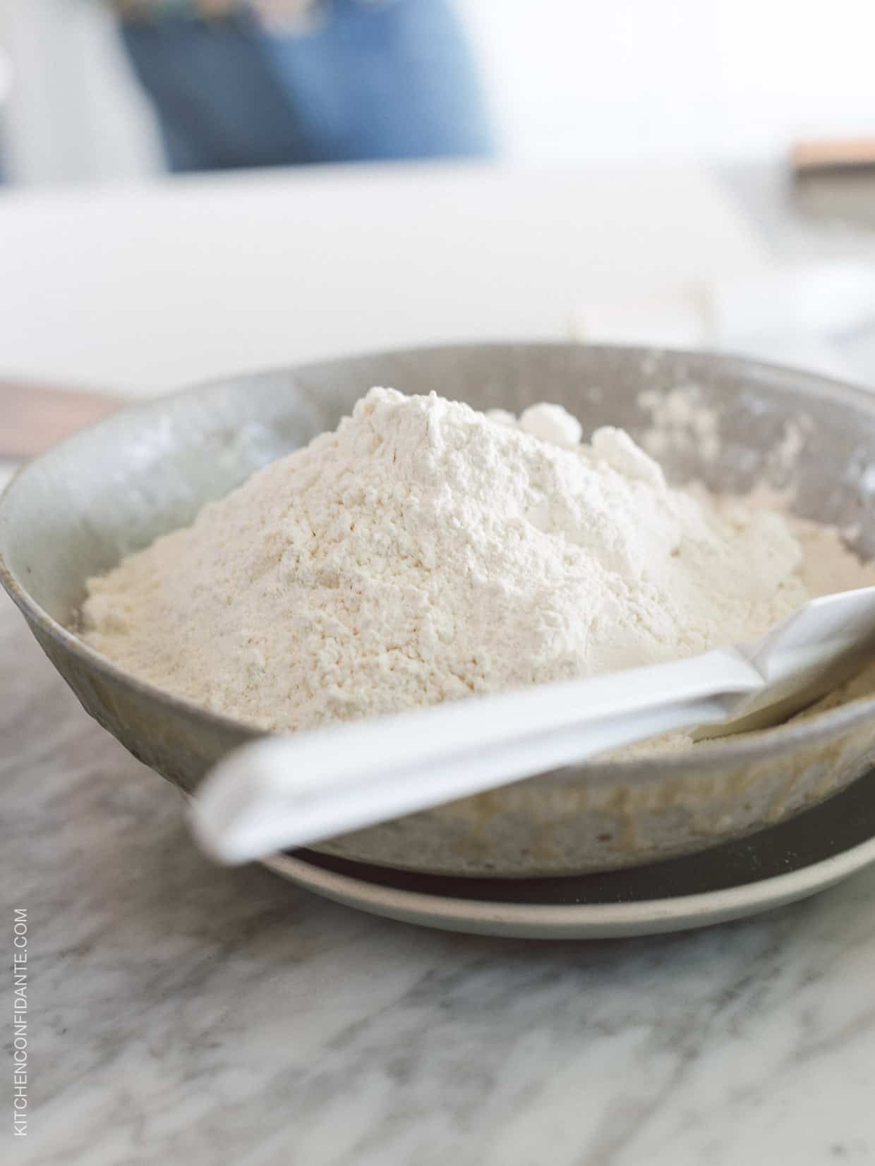 Bowl of flour on a marble surface.