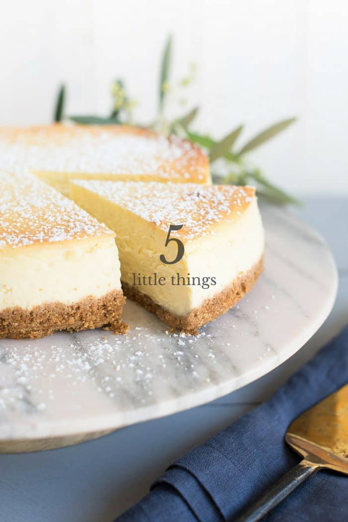 Slice of cheesecake being removed from a whole cheesecake.