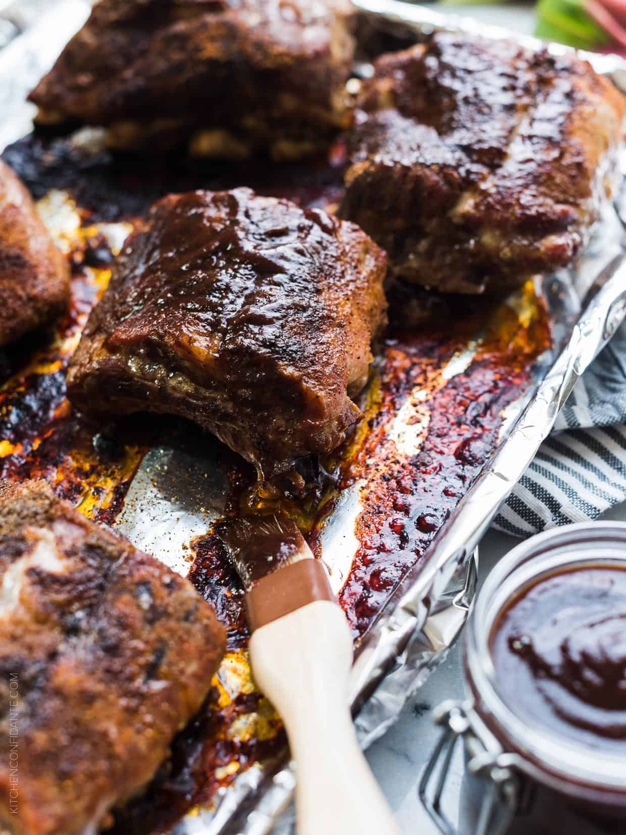 Brushing Rhubarb-Wine BBQ Sauce over grilled ribs.