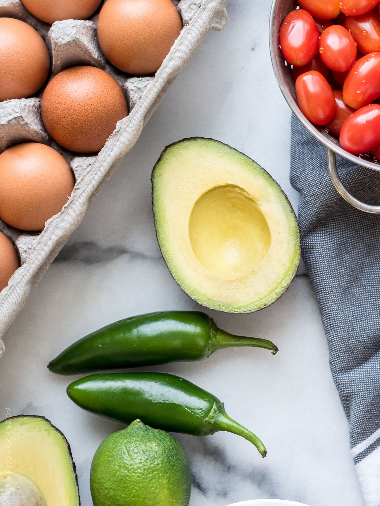 Jalapeno peppers, avocado, cherry tomatoes, and a carton of eggs.