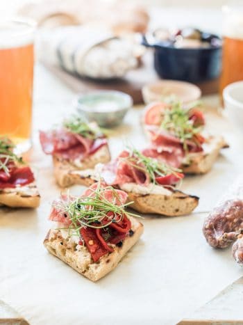 Several slices of Beer Bread Bruschetta with Salami.