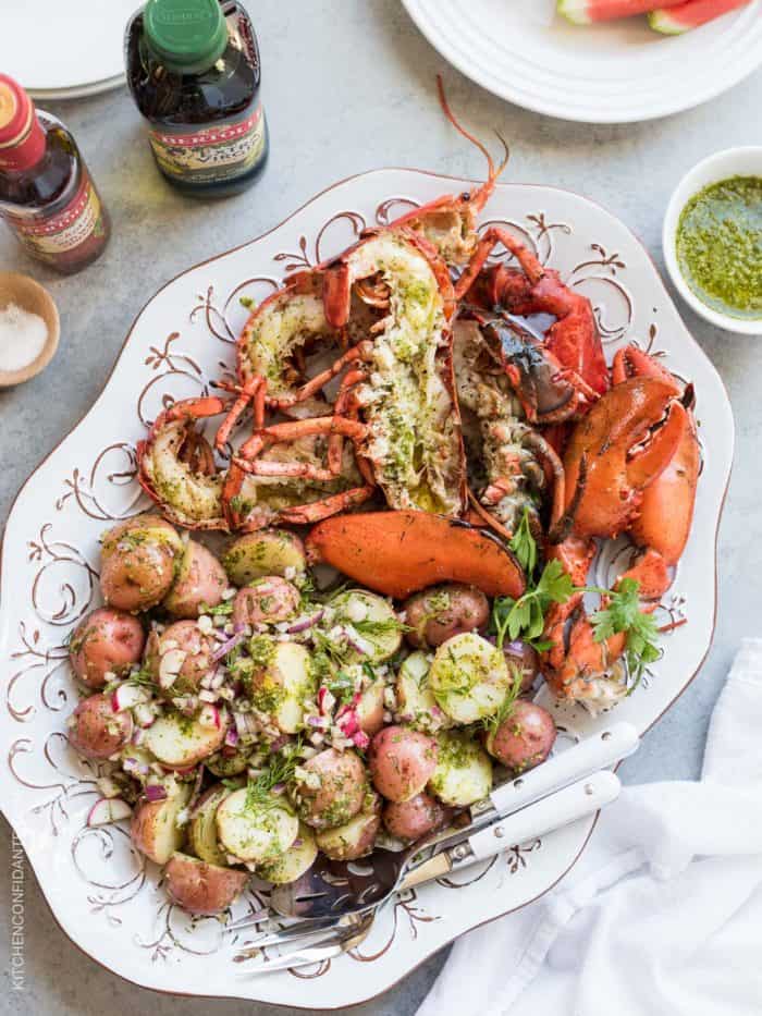 Platter filled with grilled lobster and chimichurri potato salad.