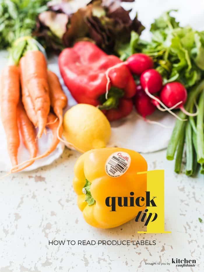 Yellow pepper with produce label surrounded by other vegetables.