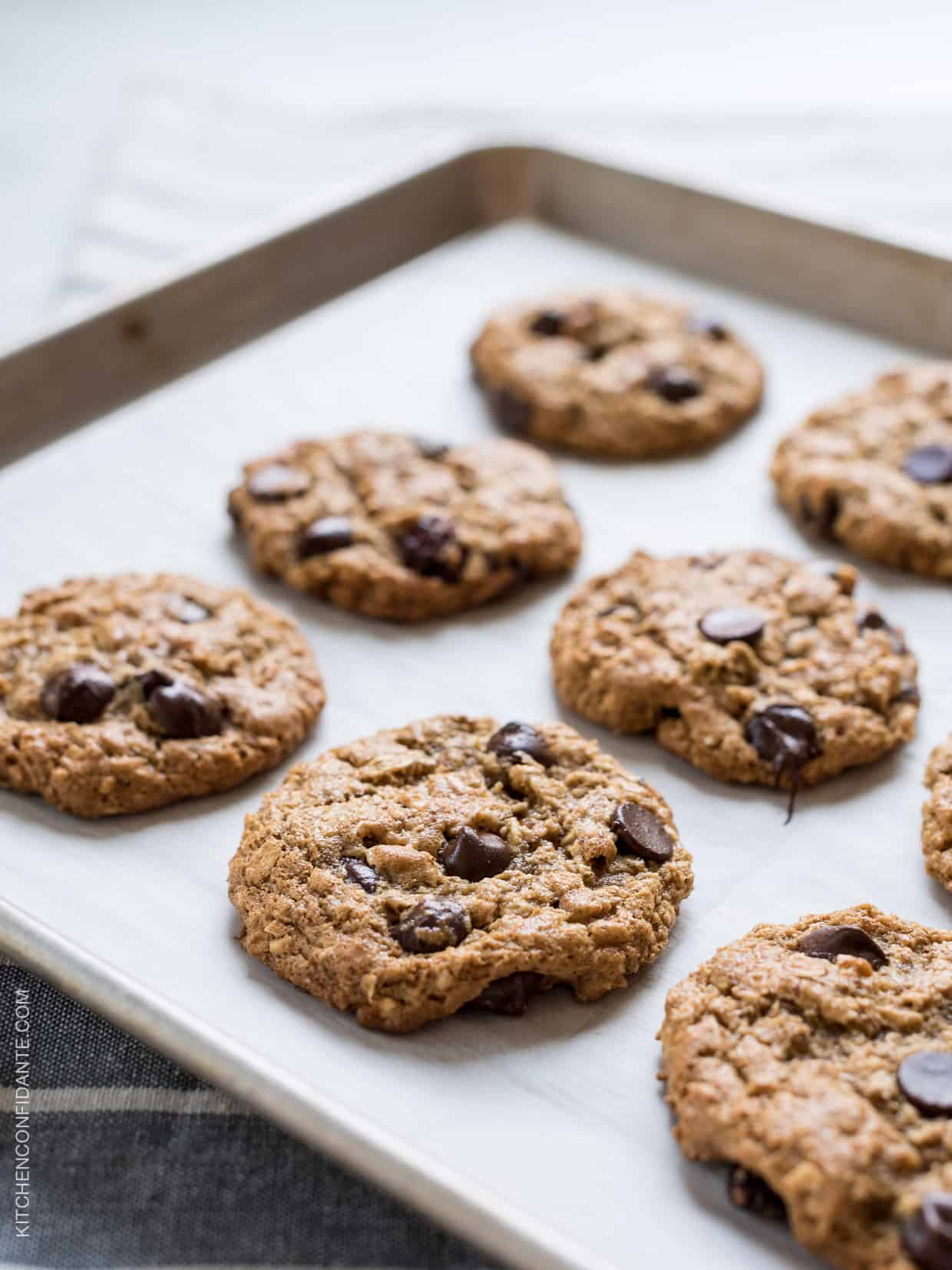 Almond Butter Oatmeal Cookies with chocolate chips on a baking sheet.