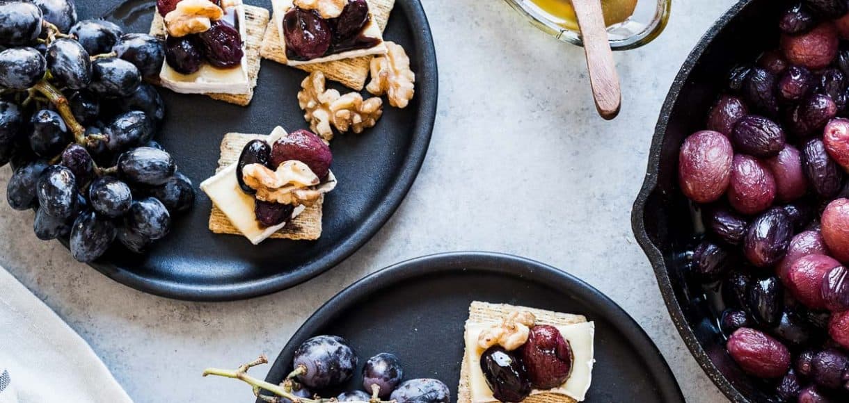 Caramelized Grape, Brie and Walnut Bites made with TRISCUIT crackers and served on dark plates.