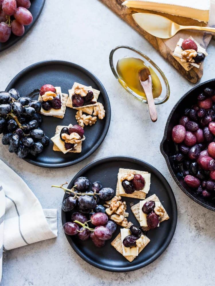 Caramelized Grape, Brie and Walnut Bites made with TRISCUIT crackers and served on dark plates.