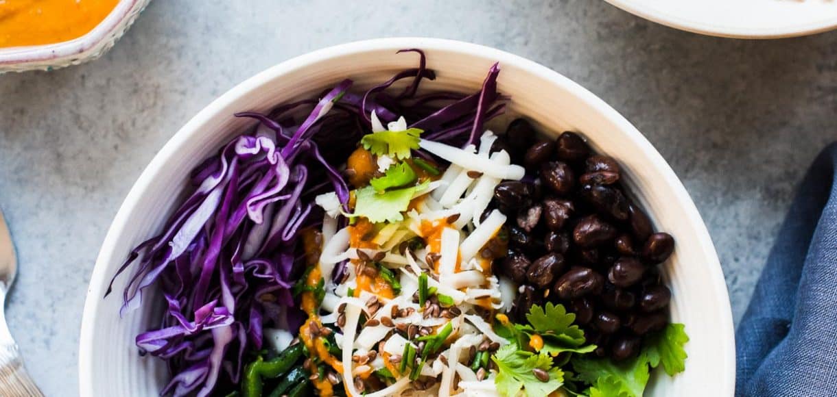 Salad prepared with shredded chicken, cabbage, black beans, charred poblanos, and pumpkin-red curry vinaigrette.