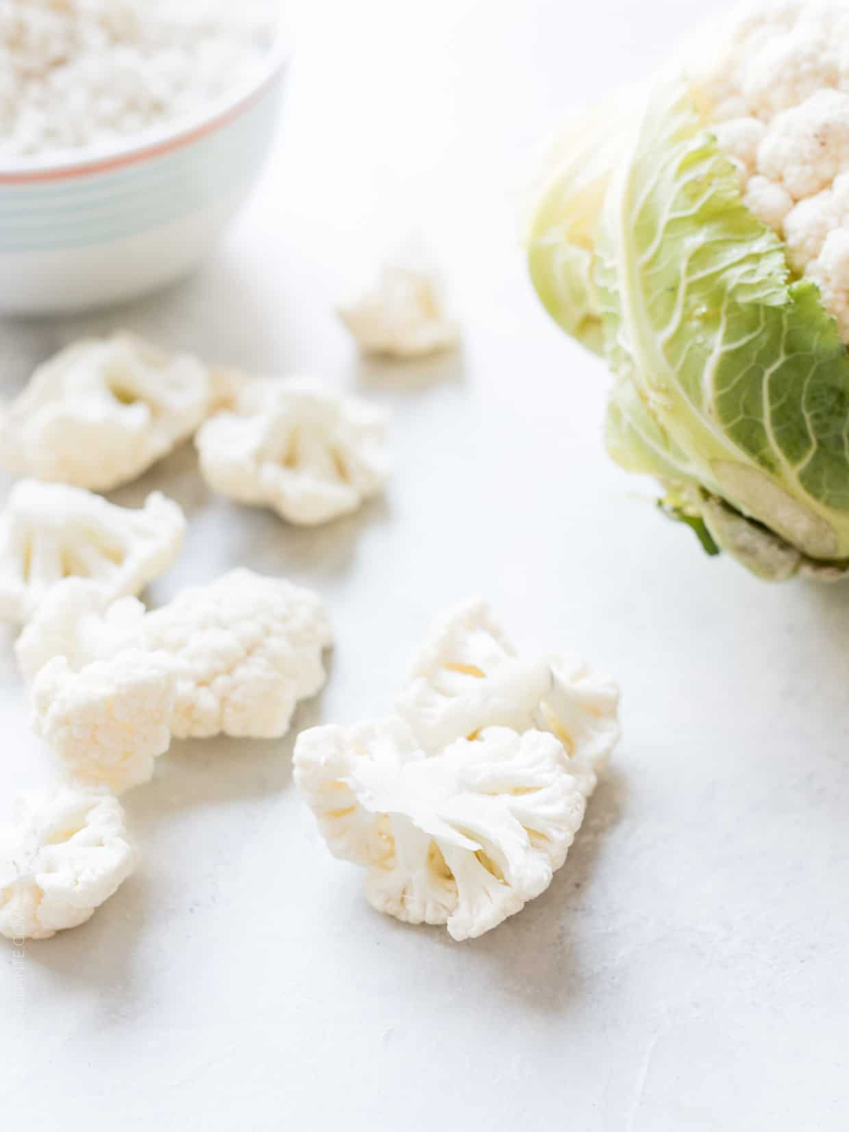 Chopped cauliflower on a white surface.