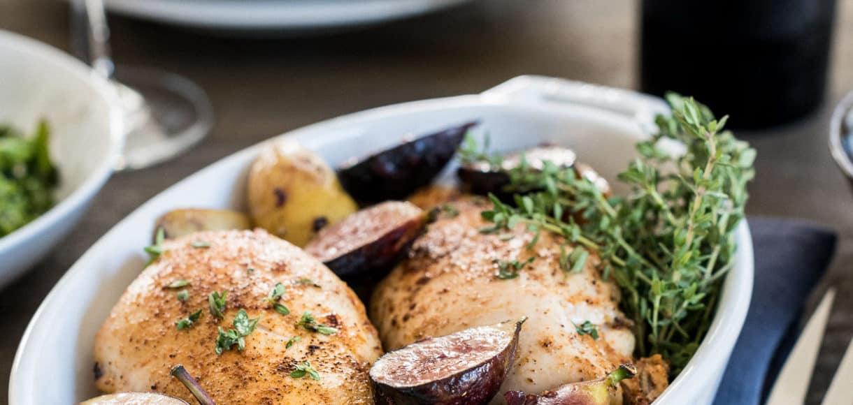 Chicken roasted in a white baking dish with fig chutney.