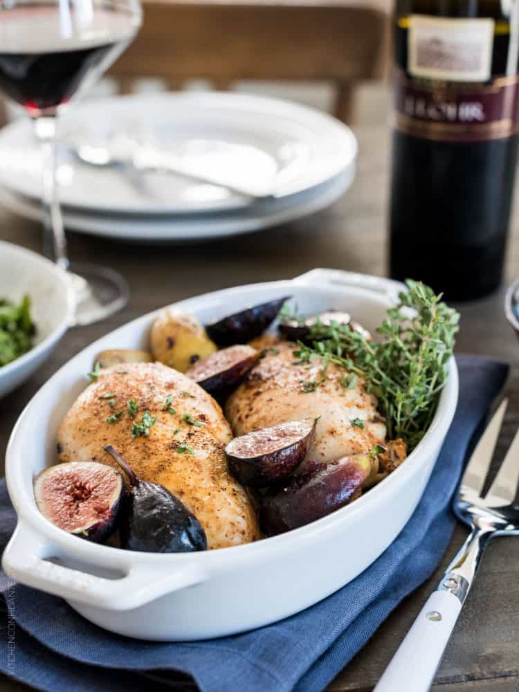 Chicken roasted in a white baking dish with fig chutney.