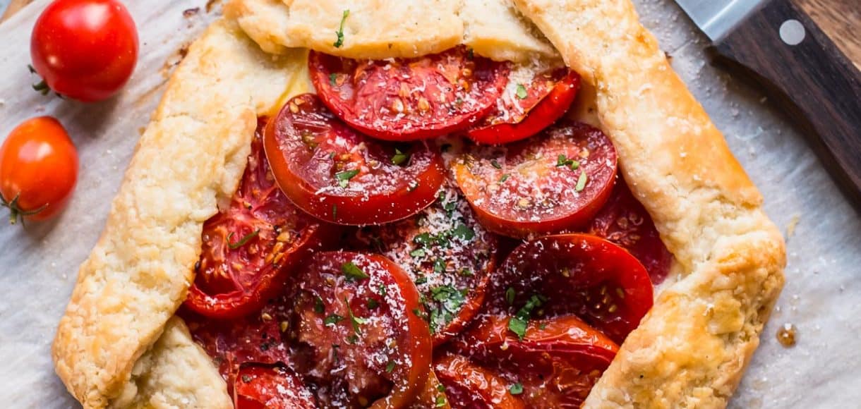 Tomato Ricotta Tart surrounded by fresh heirloom tomatoes.