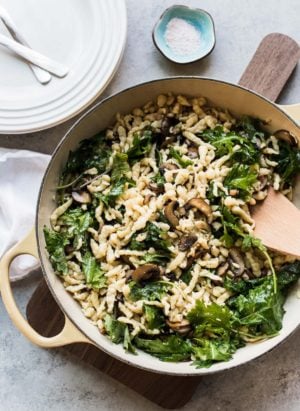 Deep sauté pan filled with homemade Spaetzle with Garlic Butter Mushrooms and Baby Kale.